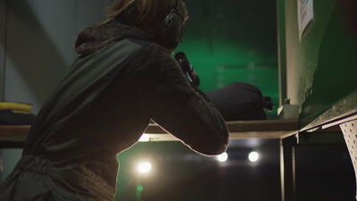 Sportschützin zielt mit Gewehr auf dem Schießstand