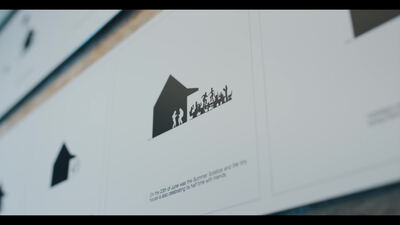 Bedrucktes Plakat mit Hausillustration und Personensilhouetten