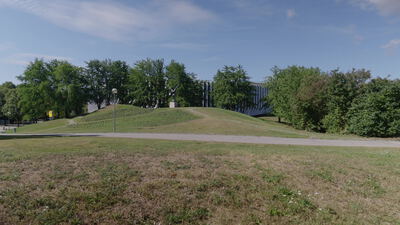 Moderne Skulptur steht auf einem begrünten Parkhügel: Skulptur im Park, abstrakte Skulptur