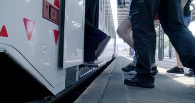 Reisende steigen am Bahnsteig aus tiefer Perspektive in den Zug