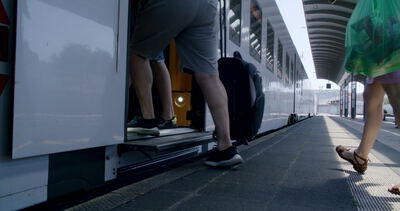 Reisende steigen mit Gepäck in einen Doppelstockzug