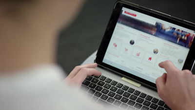 Person bedient ein Tablet und surft in einem Onlineshop