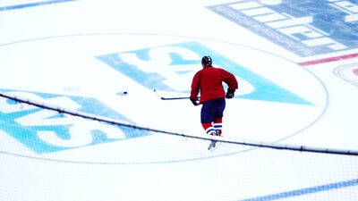 Einzelner Eishockeyspieler läuft übers Eis der Arena Einzelner Eishockeyspieler läuft übers Eis der Arena, Eishockeyspieler allein, Eishockey Weitaufnahme und Puck am Schläger