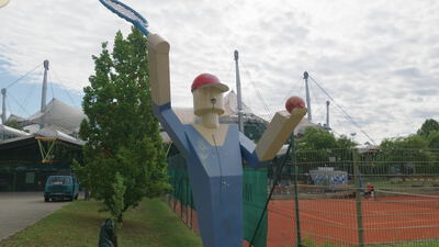 Tennisspieler Statue schwingt Schläger neben einem Tennisplatz im Park: Tennisspieler Statue, Tennisstatue