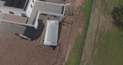 Drohne filmt das Setzen einer Betonwand auf einer Baustelle