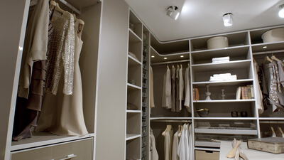 Elegantes Ankleidezimmer mit hängender Kleidung und Abendkleidern