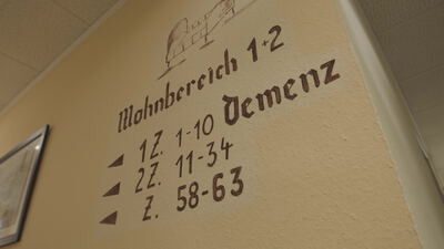Wandschild mit der Aufschrift Demenz und Wohnbereich in einem Pflegeheim
