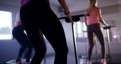 Zwei Personen springen gemeinsam an der Haltestange im Fitnessstudio