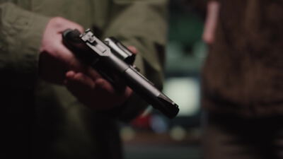 Hand hält eine schwarze Pistole auf der offenen Handfläche Hand hält eine schwarze Pistole auf der offenen Handfläche, Hand hält Pistole, Pistole in der Hand und Waffe übergeben als