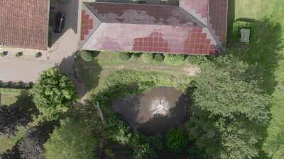 Gartenteich mit Fontäne neben Landhaus von oben Gartenteich mit Fontäne neben Landhaus von oben, Gartenteich Luftaufnahme, Drohnenaufnahme Teich und Fontäne im Garten von