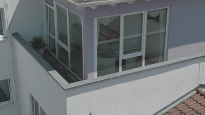 Erhöhte Ansicht einer modernen Gebäudeecke mit Wintergarten Erhöhte Ansicht einer modernen Gebäudeecke mit Wintergarten, Dachterrasse, moderne Fassade und Glasfront als 4K Stockvideo