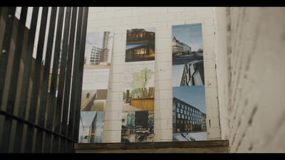Architektur Präsentationswand mit Gebäudefotos an weißer Ziegelwand