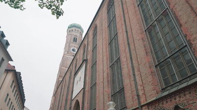 Turm der Frauenkirche München ragt über die Backsteinfassade empor: Frauenkirche München, Turm der Frauenkirche