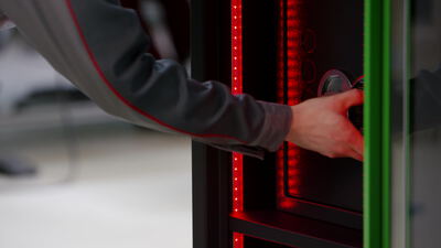 Hand tippt den Sicherheitscode am elektronischen Tresor ein