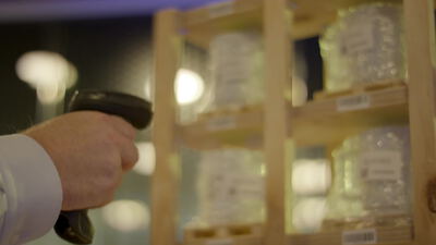 Hand scannt Barcode auf Flaschen im Warenlager