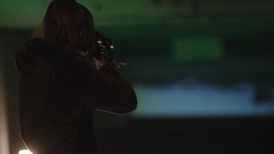 Schütze zielt als Silhouette auf die Schießbahn, Schießstand, Gewehr im Anschlag und Gehörschutz als 4K Stockvideo
