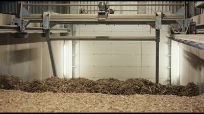 Automatische Förderanlage bewegt Biomasse in einer Industriehalle
