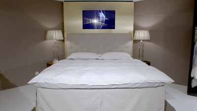 Gemütliches Hotelzimmer mit Doppelbett und zwei Nachttischlampen Gemütliches Hotelzimmer mit Doppelbett und zwei Nachttischlampen, Innenaufnahme, Bettwäsche und Schlafzimmer als 4K