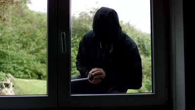 Einbrecher am Fenster von innen als Silhouette gesehen