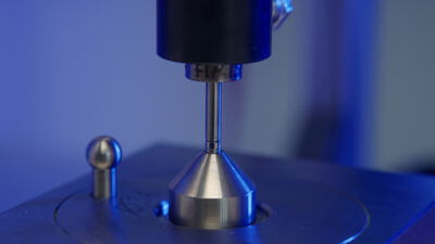 Präzise Messsonde prüft ein glänzendes Metallteil im Labor