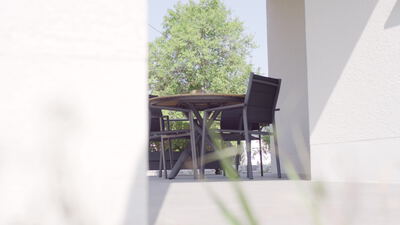 Terrasse mit Tisch und Stühlen im hellen Sonnenlicht