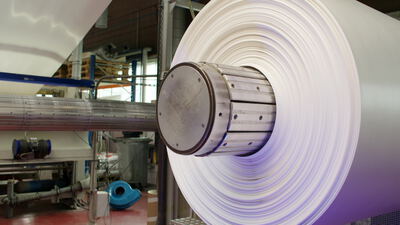 Große Materialrolle dreht sich schnell auf einer Wickelmaschine