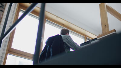 Person arbeitet am Schreibtisch am Fenster im Loft Büro