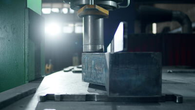 Hydraulische Presse formt einen schweren Metallblock in der Fabrik