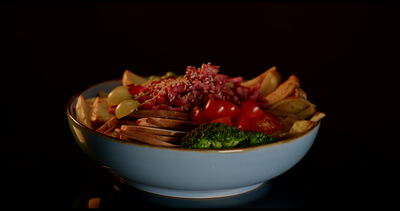 Gesunde Bowl mit Kirschtomaten Brokkoli und Edamame vor dunklem Hintergrund