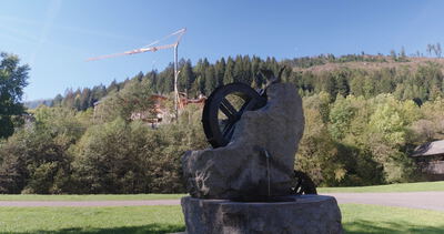 Steinbrunnen mit Speichenrad und Vogelfigur auf sonniger Wiese Steinbrunnen mit Speichenrad und Vogelfigur auf sonniger Wiese, Brunnenskulptur, Skulptur und Steinskulptur als 4K Stockvideo