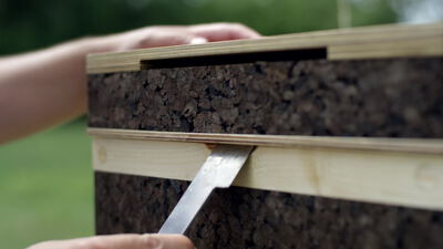 Imker öffnet Korkbeute mit dem Stockmeißel im Garten