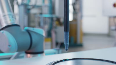 Kollaborativer Roboterarm bearbeitet ein Metallteil an der Produktionslinie