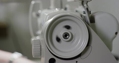 Handrad einer Industrienähmaschine dreht sich in der Textilwerkstatt