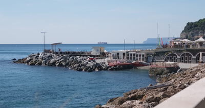 Hafenmole mit Bogenbau und roten Booten vor dem offenen Meer Hafenmole mit Bogenbau und roten Booten vor dem offenen Meer, rote Boote, kleiner Hafen und Hafenkulisse als 4K Stockvideo