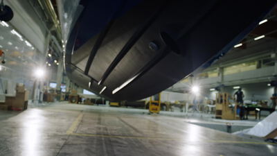Kamerafahrt unter dem keilförmigen Rumpf eines Motorboots in der Bootsfabrik