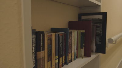 Bücher stehen im weißen Regal neben einer Treppe im Wohnraum