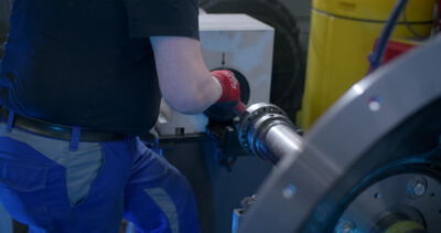 Arbeiter montiert eine Rotorwelle an einer Auswuchtmaschine im Werk