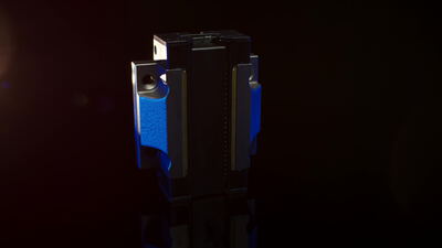 Blau eloxiertes Bauteil aus Aluminium auf schwarzer Fläche