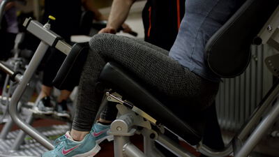 Beine trainieren an der Beinbeuger Maschine im Fitnessstudio