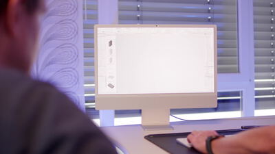 Mann gestaltet einen Raum am Computer mit einer 3D Raumplanungssoftware