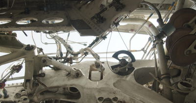 Blick von unten auf die Mechanik einer großen Industriemaschine mit Seilrollen