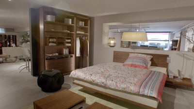 Modernes Schlafzimmer mit Holzschrank und Doppelbett unter einer Pendelleuchte