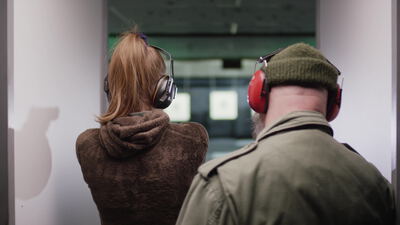Zwei Personen zielen auf Papierzielscheiben im Schießstand