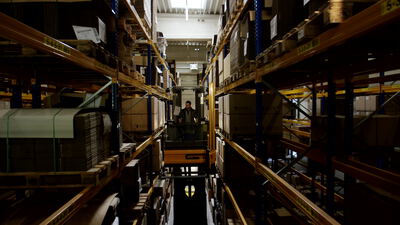 Gabelstapler fährt durch ein großes Hochregallager, Gabelstapler im Hochregallager, Logistikhalle und Gabelstapler im Lager