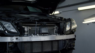 Fahrzeugfront mit geöffneter Haube in der Autowerkstatt