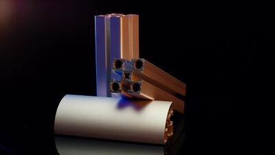 Aluminiumprofil im Querschnitt neben rundem Profilstab