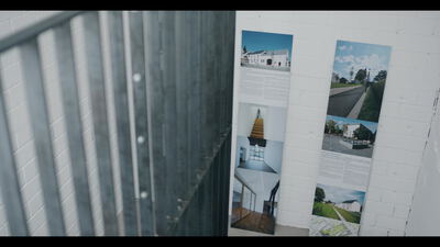 Architektur Ausstellung mit Postern hinter Metalllamellen