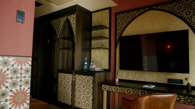 Orientalisches Hotelzimmer mit verziertem Schrank und Minibar