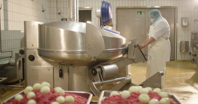 Kutter in der Wurstproduktion mit Hackfleisch und Zwiebeln