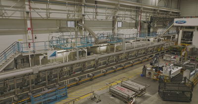 Weiter Blick über eine große industrielle Produktionshalle mit Maschinen